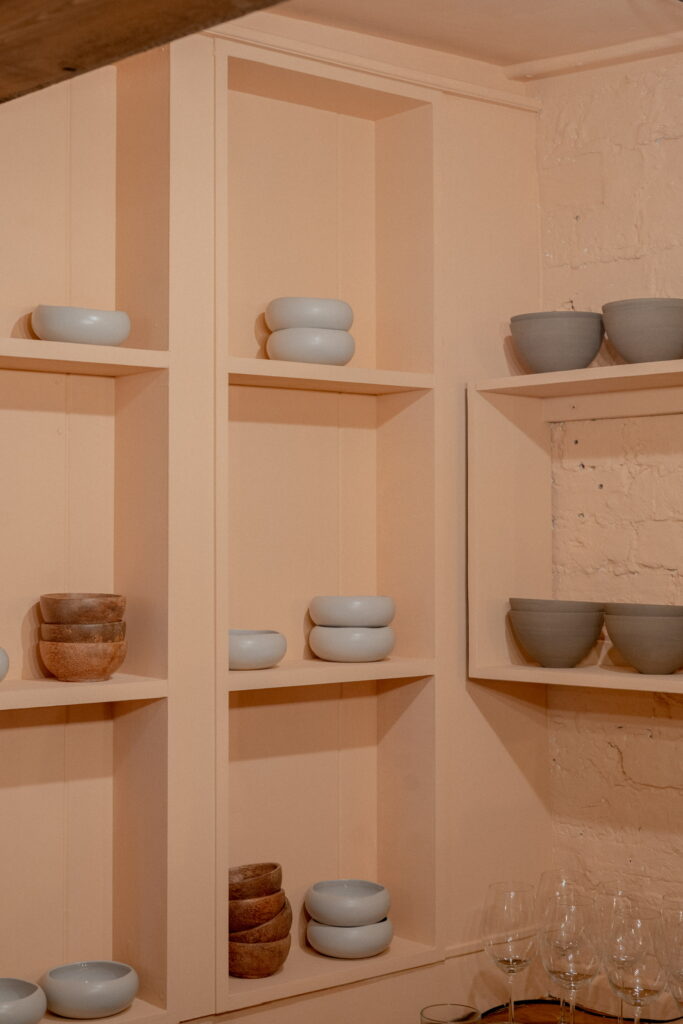 Beautiful clay coloured restaurant shelving with minimal display 